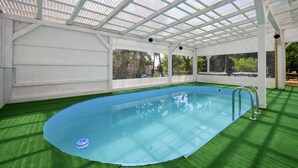 An indoor swimming pool with a glass ceiling, surrounded by artificial grass. - Pet friendly home in Bjelovar with sauna (Curlovac)