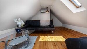 A modern loft apartment with a black leather sofa, a glass dining table, and a wooden floor. - Awesome home in Jaskovo with heated swimming pool (Jaskovo)