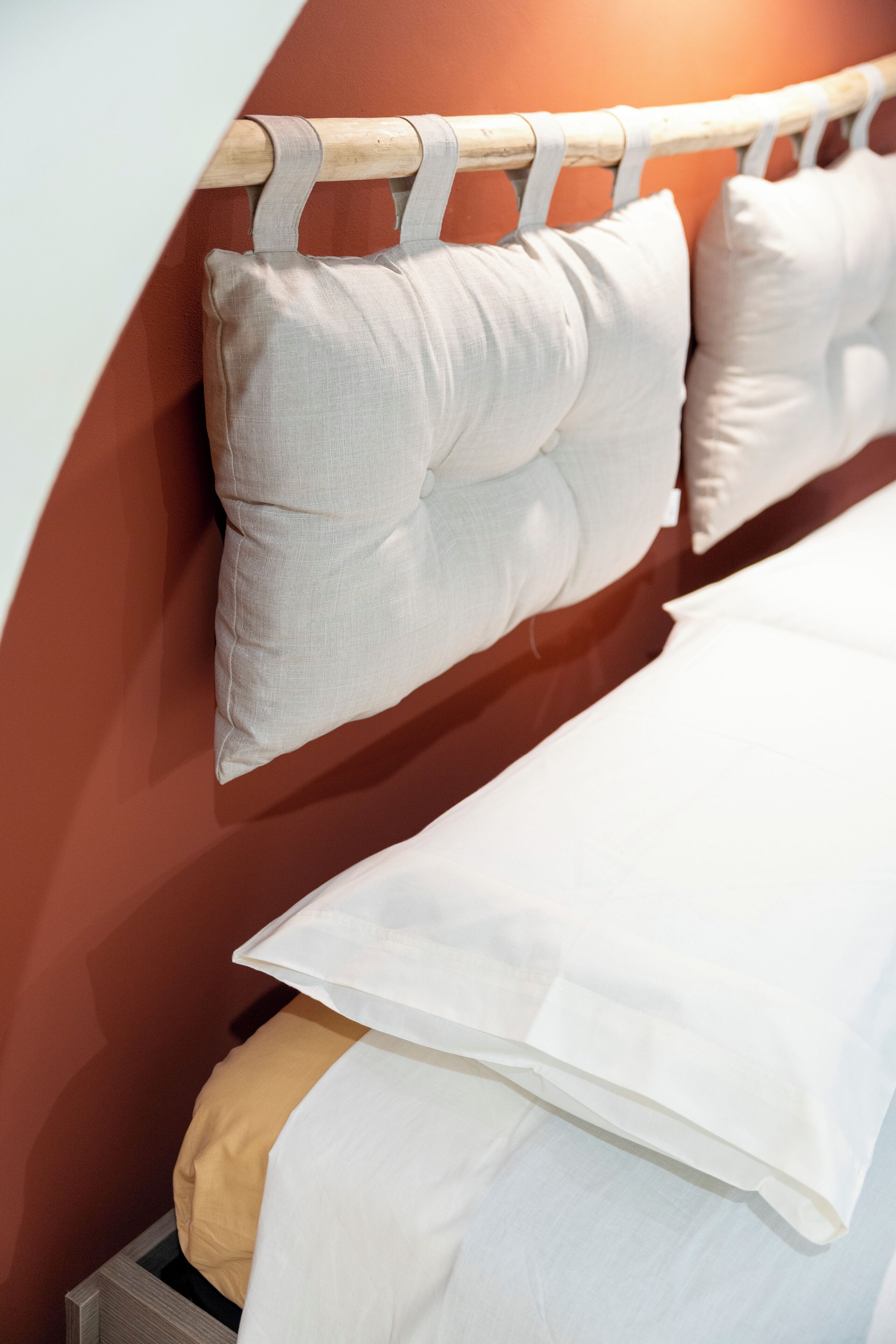 A bed with white bedding and a wooden headboard.