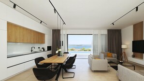 A modern living room with a dining area, a kitchen, and a large window with a view of the sea. - Awesome home in Tkon with private swimming pool, can be inside or outside (Tkon)