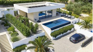 A modern house with a swimming pool, outdoor seating, and a car parked in front. - Awesome home in Tkon with private swimming pool, can be inside or outside (Tkon)