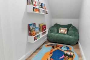 Eine gemütliche Leseecke für Kinder mit Regalen und einem Sitzsack.