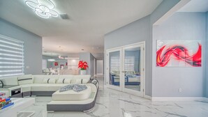 A modern living room with a sectional sofa, a coffee table, and a large abstract painting on the wall.