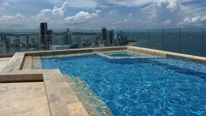 Ein Infinity-Pool auf dem Dach mit Blick auf die Stadtlandschaft.