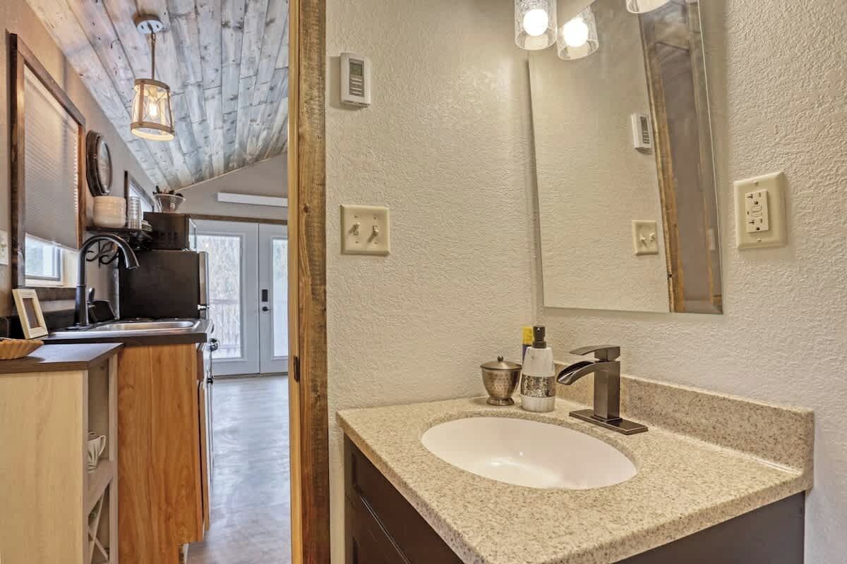 Une salle de bain moderne avec un lavabo sur pied, un grand miroir et un plafond en bois.