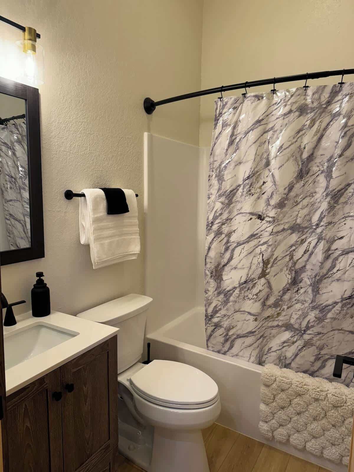 A bathroom with a toilet, sink, and bathtub.