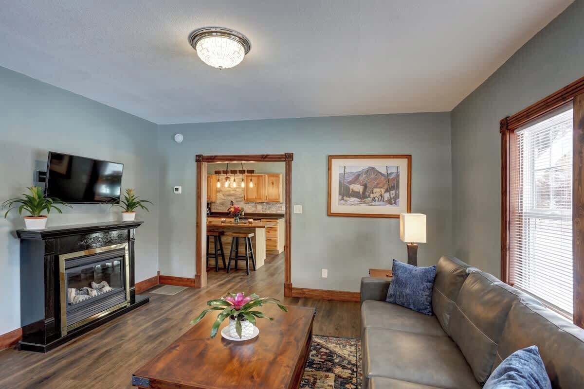A living room with a fireplace, sofa, coffee table, and a TV.