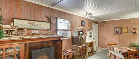 A room with a fireplace, wooden furniture, a television, and a framed picture on the wall.