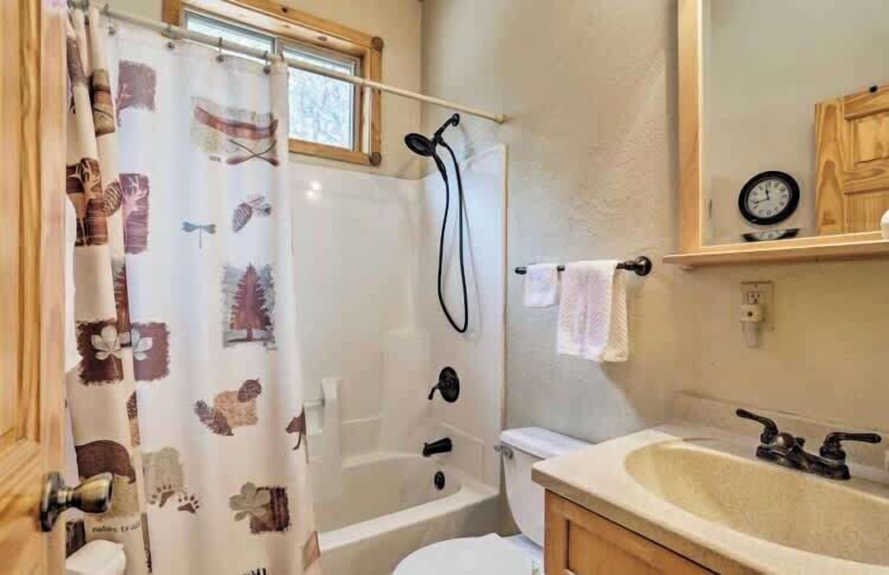 Een badkamer met douche, toilet en wastafel.