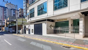 Un edificio con una puerta de garaje cerrada, un letrero que dice "Residential Gold" y una entrada protegida por una reja.