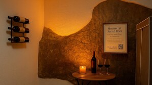Un rincón acogedor con un botellero, una vela y un cartel enmarcado sobre una pared con textura.
