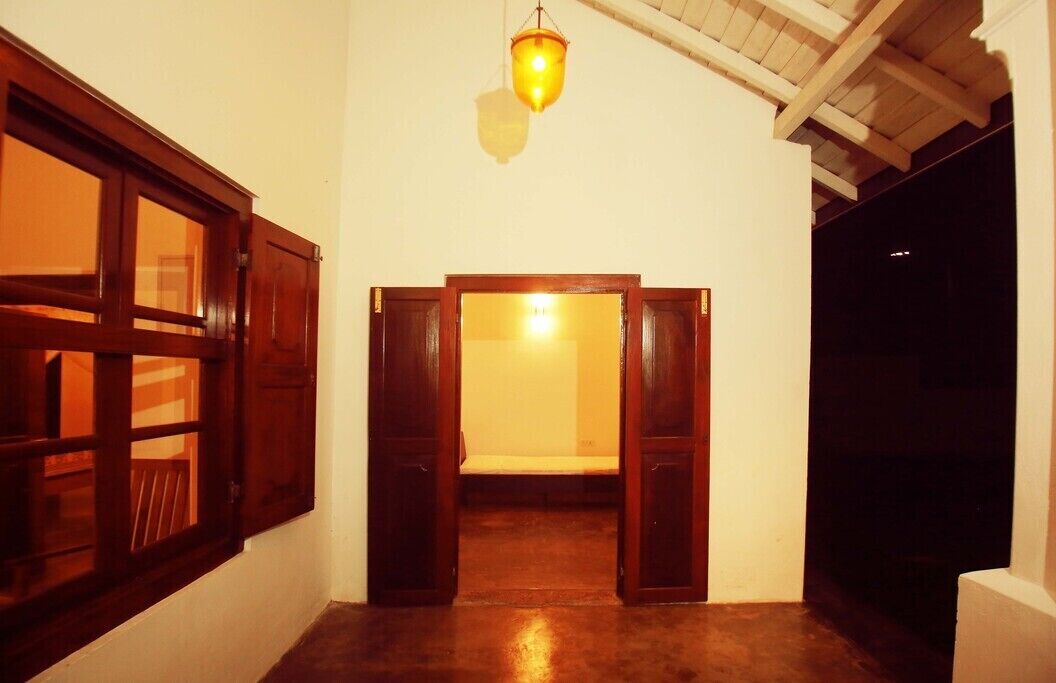 Un passadís amb portes de fusta i un llum penjant.