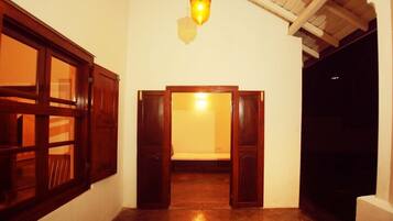 Un passadís amb portes de fusta i un llum penjant.