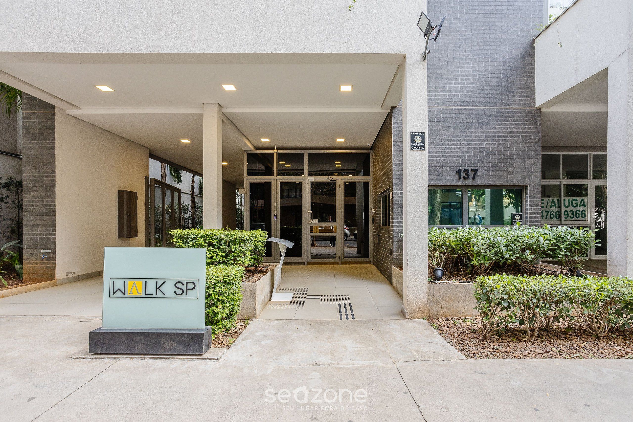Entrada de un edificio moderno con un letrero que dice "WALK SP" y el número "137" en la pared.