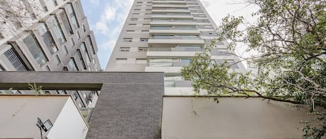 Un edificio de gran altura con múltiples balcones y un diseño arquitectónico moderno.