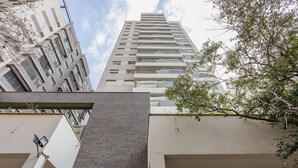 Een hoog gebouw met meerdere balkons en een modern architectonisch ontwerp.