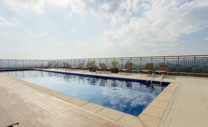 A rooftop pool area with lounge chairs and a clear view of the city skyline. - Apt w/ Gourmet Balcony 190m From the Metro Wal0714 (São Paulo)