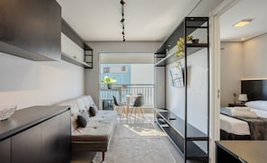 A modern hotel room with a sofa, a dining table, and a bed. - Apt w/ Gourmet Balcony 190m From the Metro Wal0714 (São Paulo)