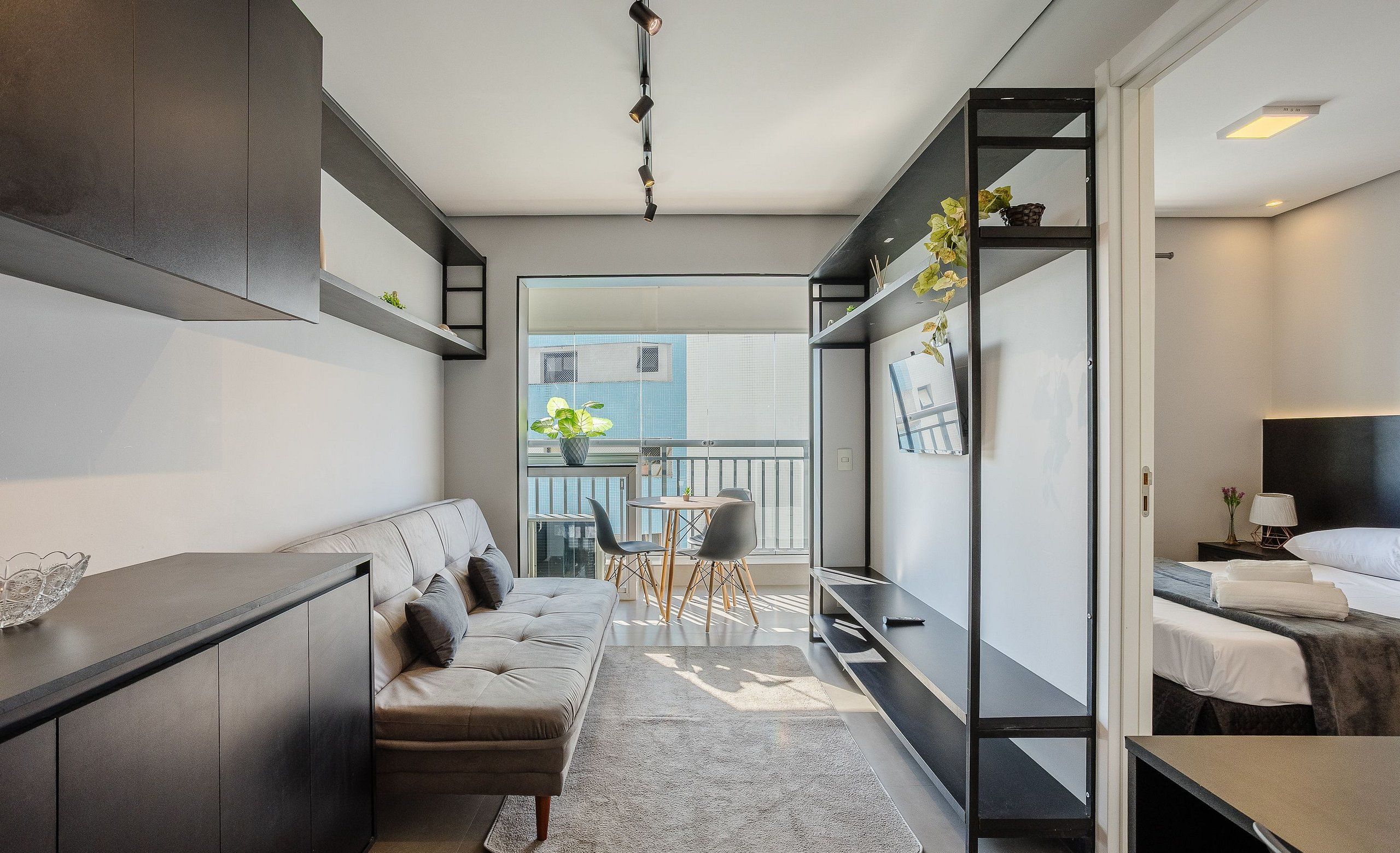 Una habitación de hotel moderna con sofá, mesa de comedor y cama.