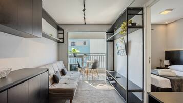 Una habitación de hotel moderna con sofá, mesa de comedor y cama.