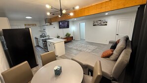 A modern living space with a kitchen, dining area, and seating area.