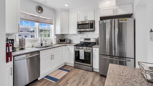 A modern kitchen with white cabinets, stainless steel appliances, a built-in oven, and a microwave. - Professionally Managed | Walk to Beach (Seaside Heights)