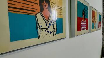 A series of framed artworks on a wall, each depicting a different figure in a stylized manner.