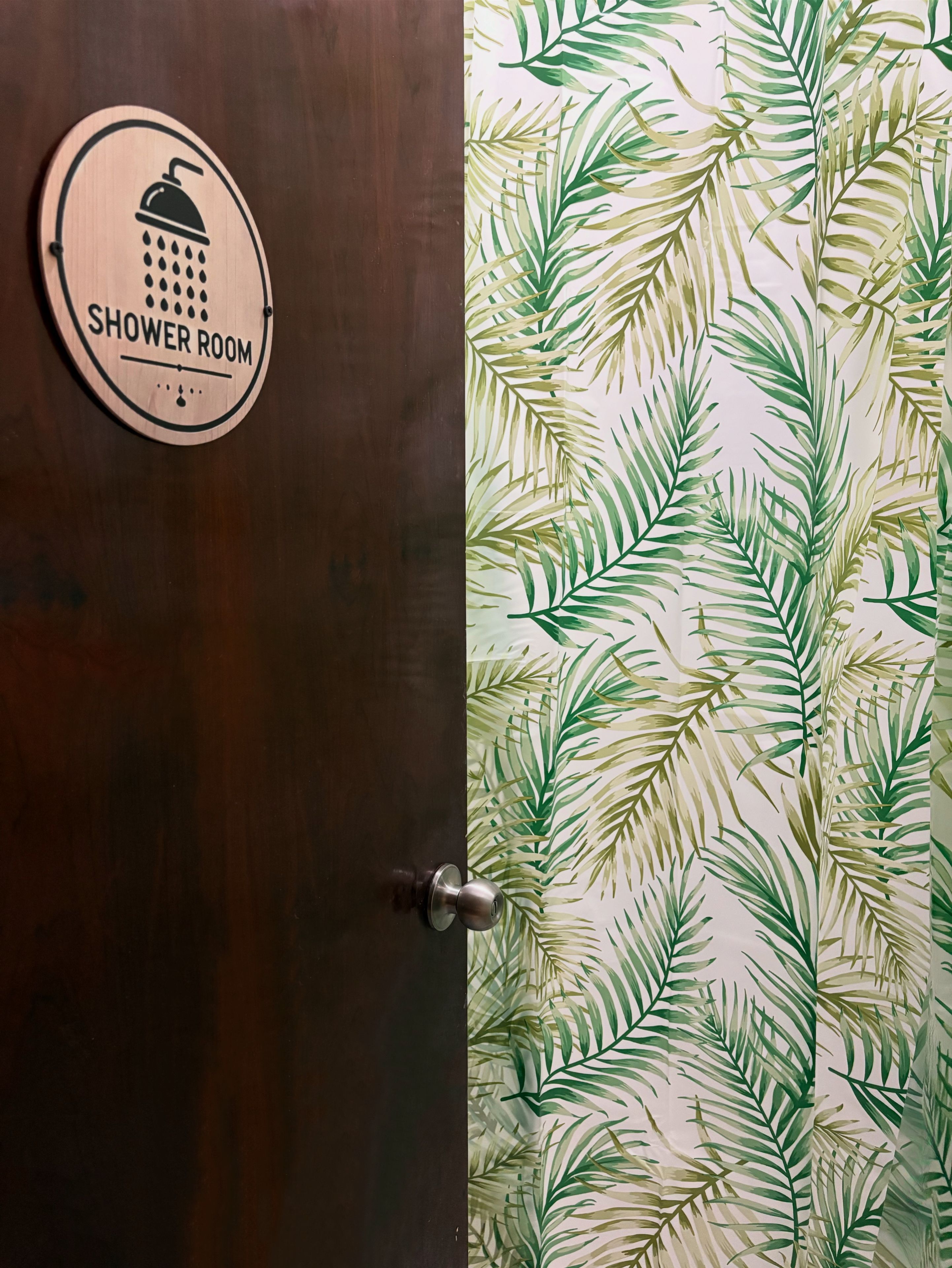 Una puerta de madera con un letrero que dice "SHOWER ROOM" y un picaporte.