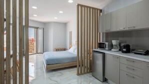 A modern bedroom with a bed, a nightstand, and a wooden partition. - Πολυτελής σουιτα με ιδιωτικη πισινα και υπέροχη θέα στο Αιγαίο! (Paros)