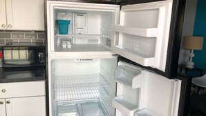 A kitchen with a built-in microwave, a refrigerator with multiple shelves, and a tiled backsplash. - 2BR Room at Alexander’s Landing. Walk to Indiana Beach + Pool Access (Monticello)