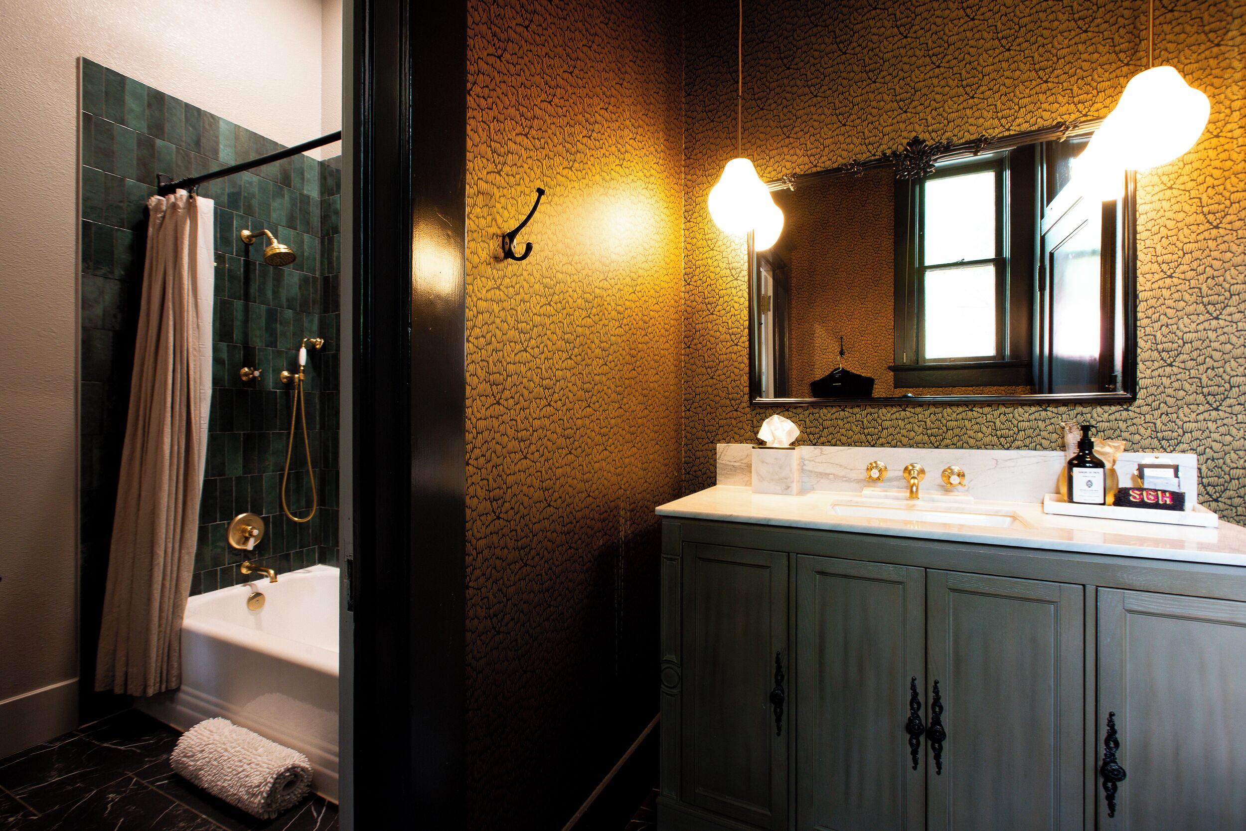 A bathroom with a bathtub, shower, vanity with a mirror, and a towel rack.