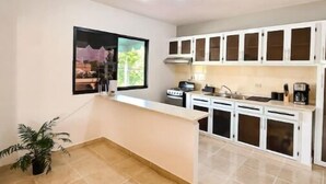 A spacious kitchen with white cabinets, a central island, and a large window. - Rango #3 – Your Perfect Space in Cabrera (Cabrera)