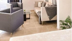 A modern living room with a sofa, a chair, a small table, and a chandelier. - Rango #3 – Your Perfect Space in Cabrera (Cabrera)