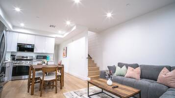 A modern apartment with a kitchen, dining area, and living room.