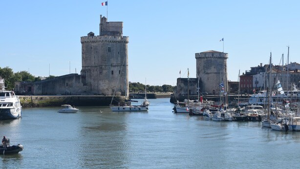 A harbor with a historic tower and a smaller tower, surrounded by boats and buildings. - 1 bedroom cozy home in La Rochelle (La Rochelle)