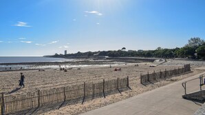 A beach with a wooden fence and a concrete walkway. - 1 bedroom cozy home in La Rochelle (La Rochelle)