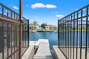 A marina with docked boats, a clear sky, and a residential area in the background. - 6BR Waterfront • Direct Gulf • Fire Pit • Biliards (Hernando Beach)