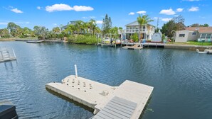 A marina with docked boats, a floating dock, and houses in the background. - 6BR Waterfront • Direct Gulf • Fire Pit • Biliards (Hernando Beach)