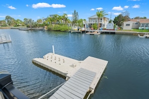 A marina with docked boats, a floating dock, and houses in the background. - 6BR Waterfront • Direct Gulf • Fire Pit • Biliards (Hernando Beach)