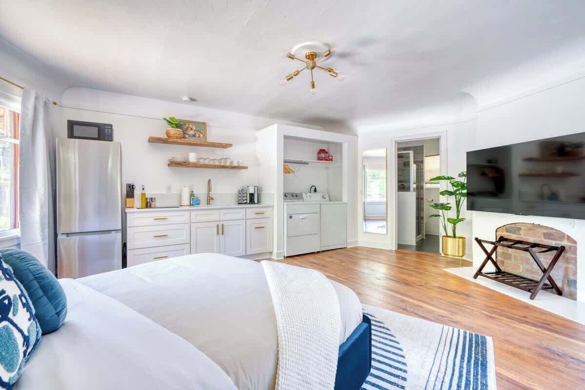 Una cocina moderna con gabinetes blancos, microondas integrado y ventilador de techo.