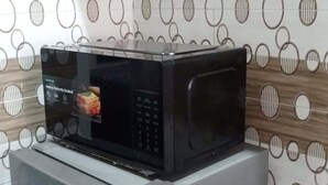 Una cocina con un microondas sobre el refrigerador.