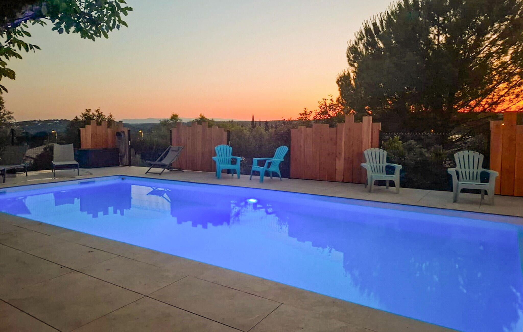 Une piscine dotée d’une terrasse en bois, entourée d’une clôture en bois et d’arbres.