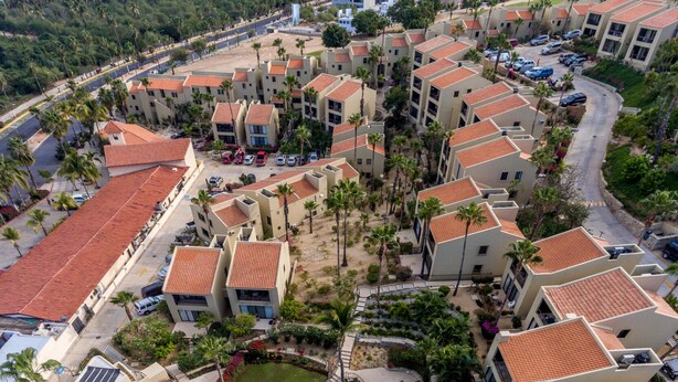 Un complexe hôtelier comprenant plusieurs bâtiments, une piscine et offrant une vue sur la plage.