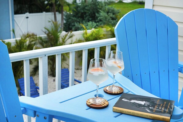 A blue chair with two glasses of a clear beverage and a book titled "No Time Like the Future" by Michael J. Fox. - 2/2 condo one block from beach & golf cart, kayaks (Indian Rocks Beach)