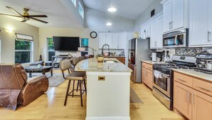 A spacious kitchen with white cabinets, a large island, and stainless steel appliances. - Walkable East Austin Oasis with Jacuzzi (Austin)