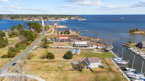 A coastal town with a marina, houses, and a road leading to the water.