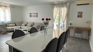 Una sala de estar moderna con una mesa de comedor, un sofá y un escritorio.
