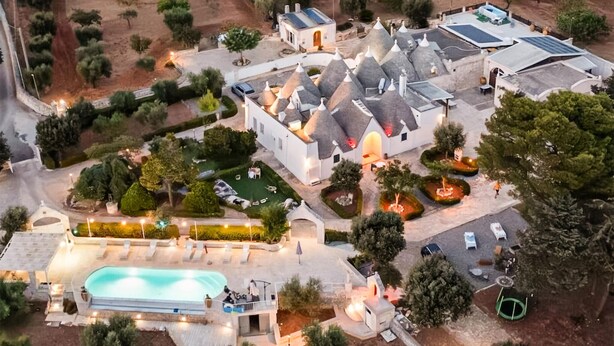 A residential area with a swimming pool, solar panels, and a small building with a conical roof. - Amazing home in Cisternino (Cisternino)