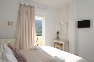 Un dormitorio con una cama, un escritorio, un espejo y un televisor.