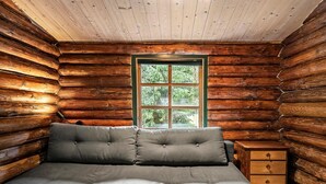 A log cabin room with a bed, a window, and a wooden nightstand. - Beautiful home in Præstø with WiFi (Præstø)
